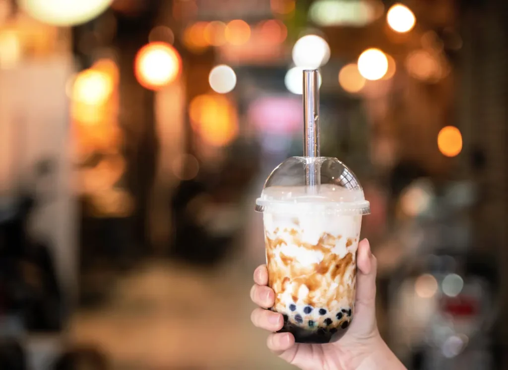 A hand holding bubble tea boba in a shop in Budapest