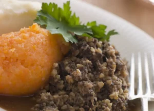 a plate of haggis, neeps and tatties with a fork