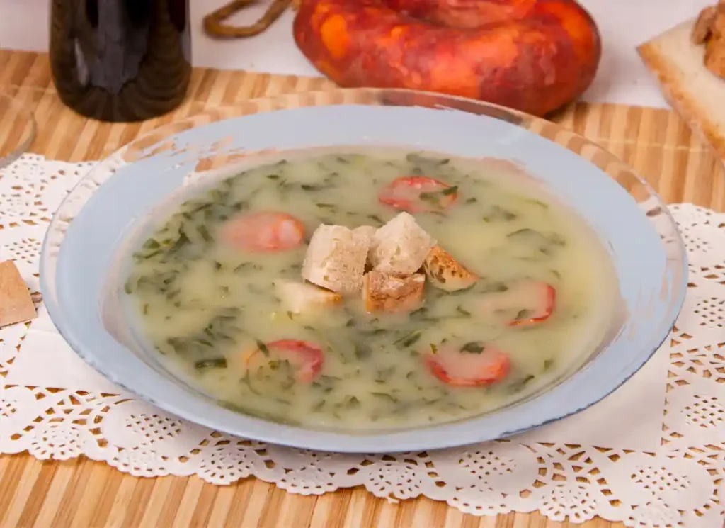 A bowl of Caldo Verde soup on a traditional Portuguese tablecloth