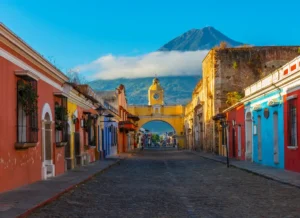 A colourful street in Antigua, Guatemala with a volcano in the background