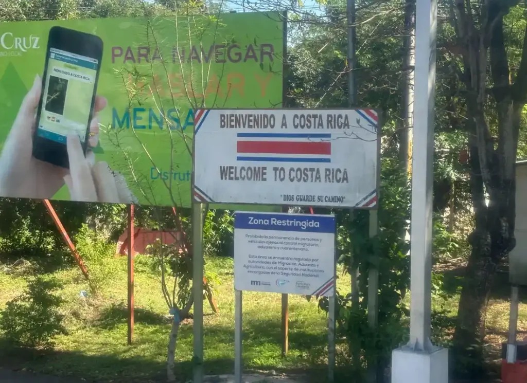 A sign saying "welcome o Costa Rica" taken through the window of the bus from Nicaragua to Costa Rica