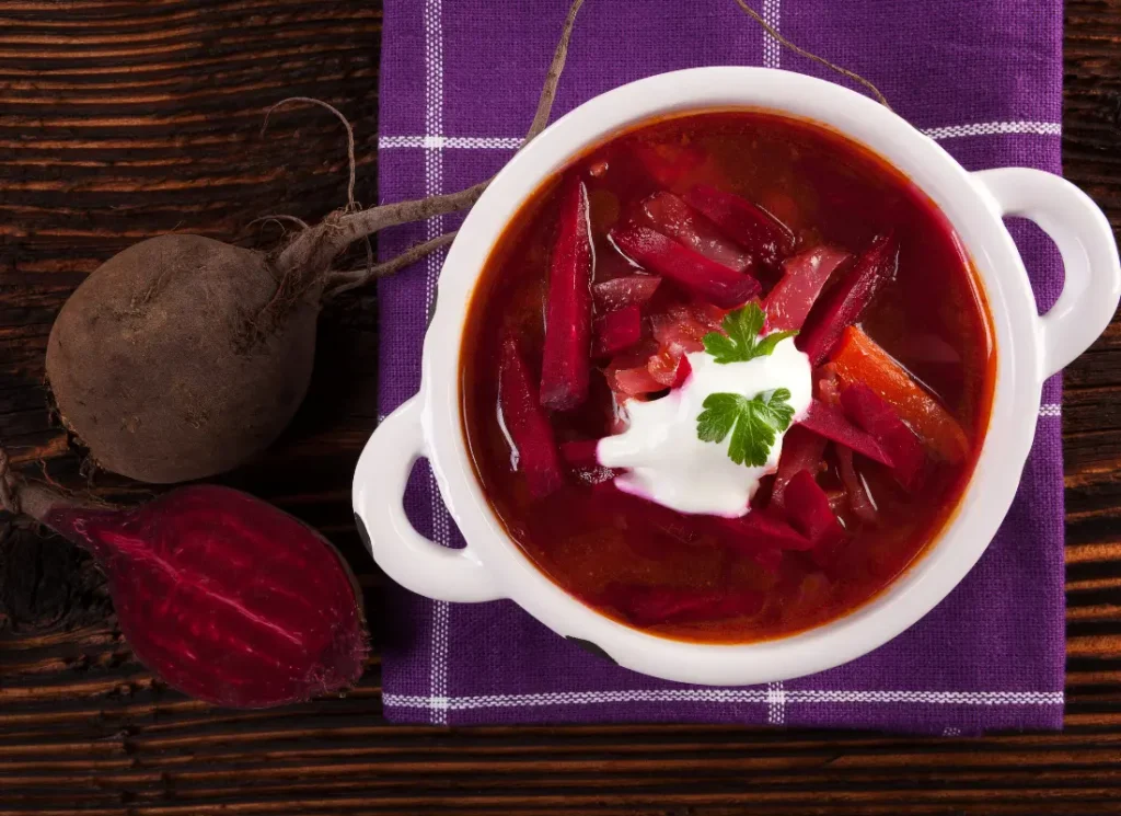 A picture of borscht soup next to two beetroot