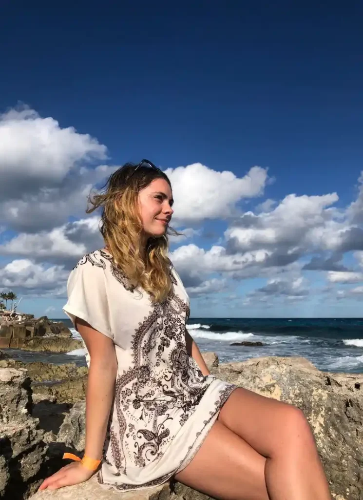 Isabella sat on some rocks in Cancun, Mexico