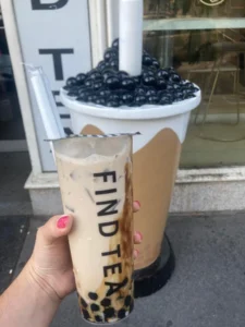 A cream and brown cup of bubble tea in front of Find Tea in Budapest