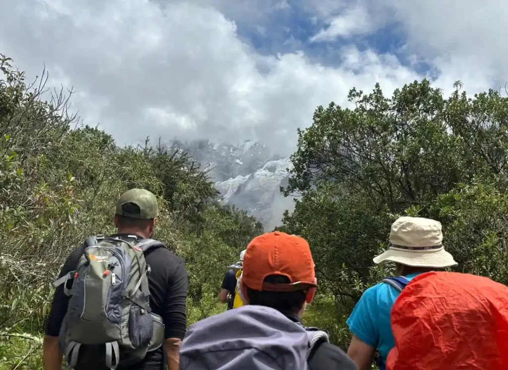 Three people wearing hats and backpacks on their trek to Machu Picchu