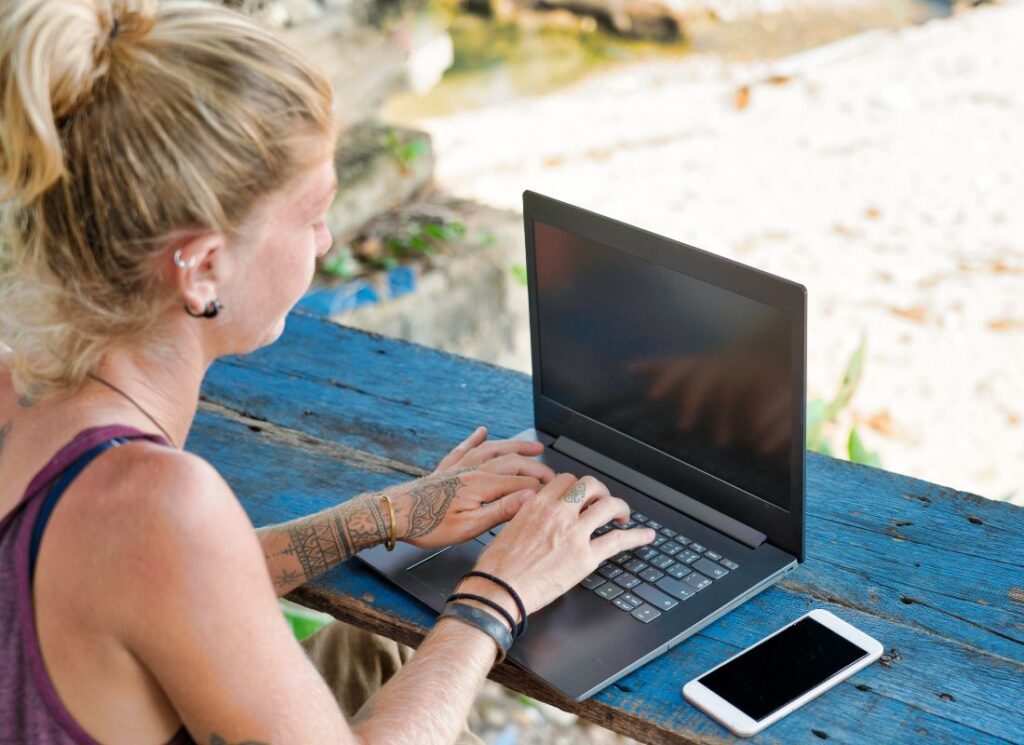 a digital nomad remote working by the beach