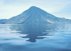 Lake Atitlan, a volcano and the reflection of it in the lake water