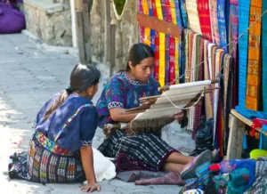 Two Guatemalan women working at a textile shop in Guatemala, where you can volunteer